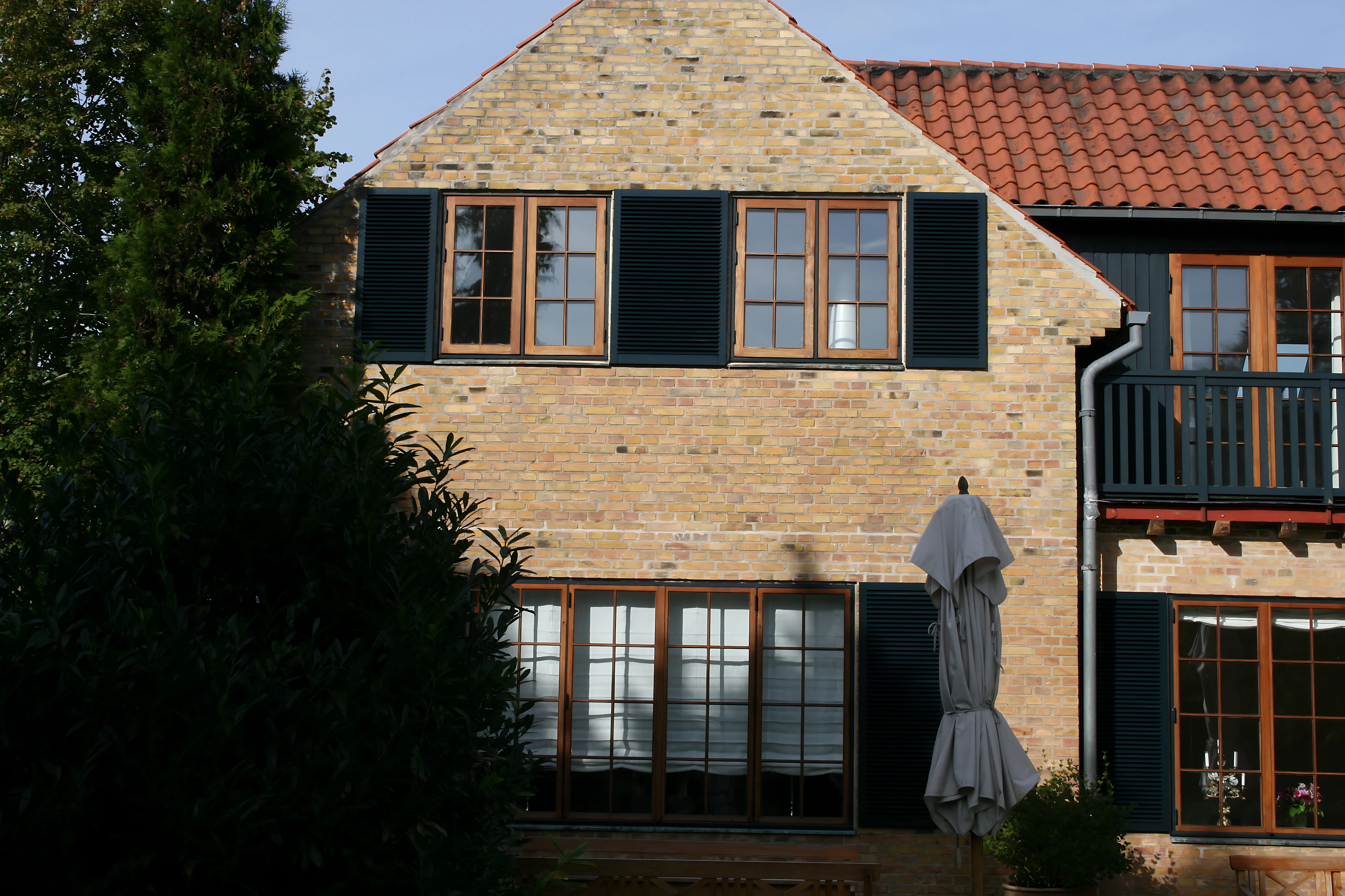 Mørke Kvik-skodder på en murstensfacade